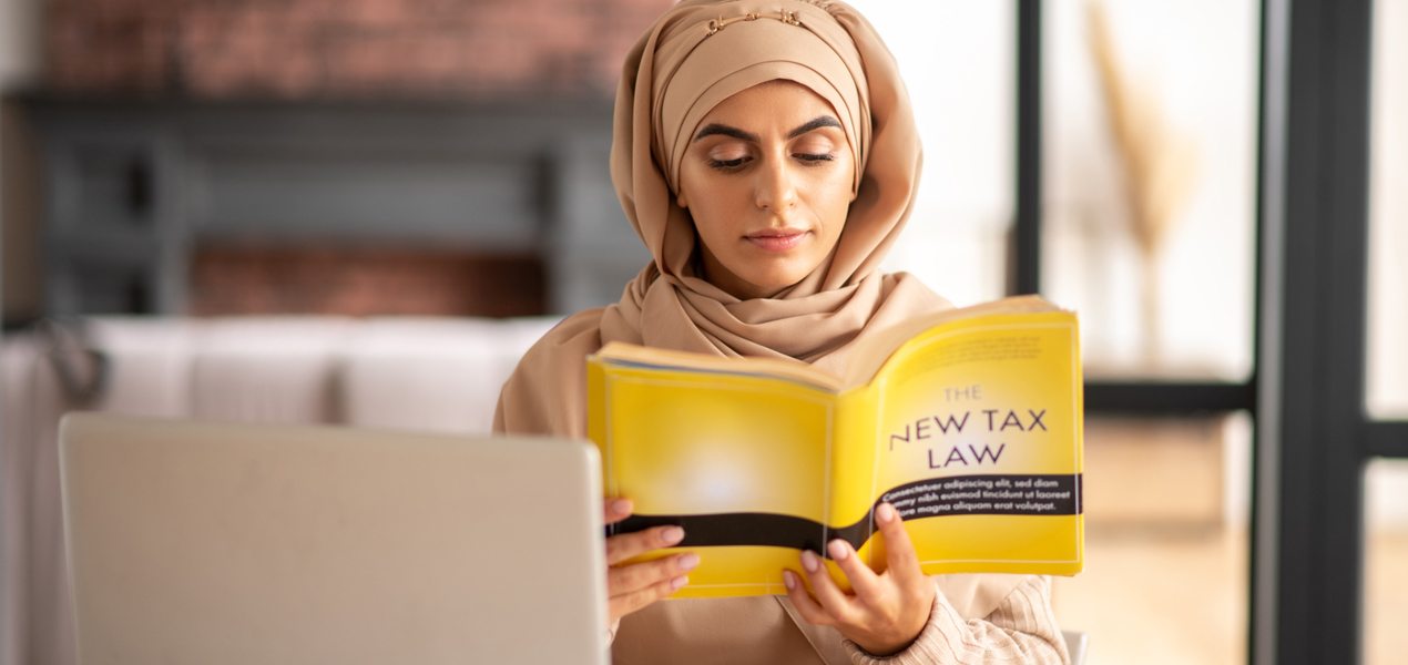 Muslim girl reading a book about tax law.