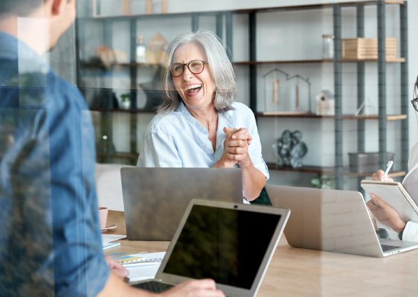 Female supervisor laughing during a meeting.