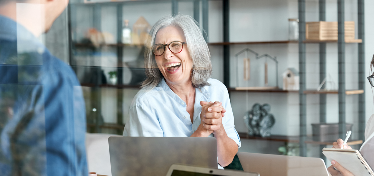 Female supervisor laughing during a meeting.